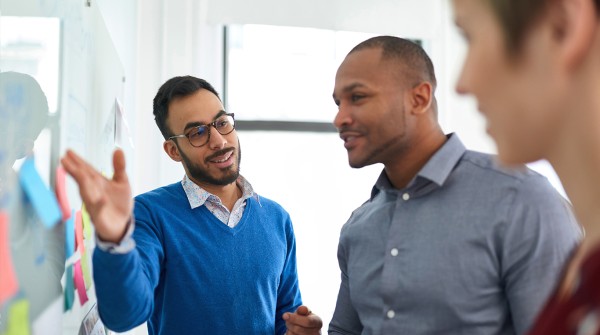 A group of professionals reviewing information on a whiteboard